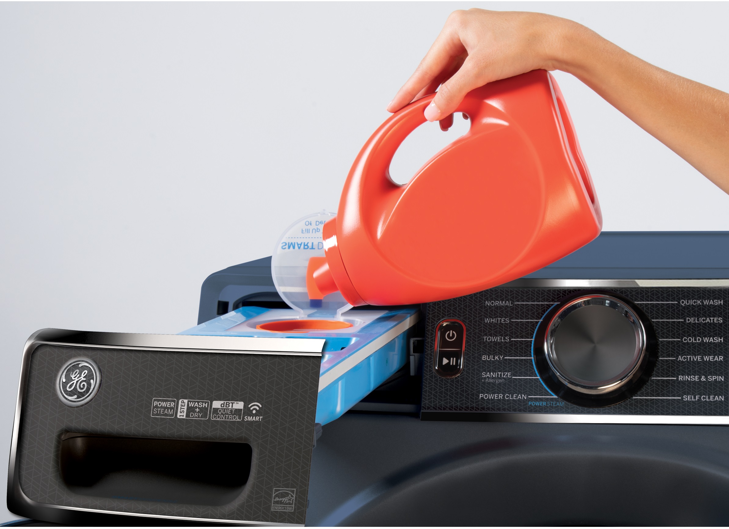 A person pouring detergent into a GE front load washer 