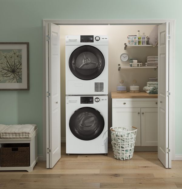A GE front load washer and dryer stacked in a laundry closet 