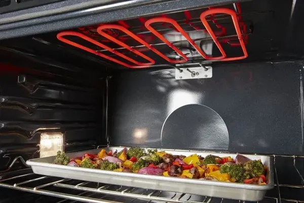 A close-up look at the heating element inside the Whirlpool WOES3030LS  oven cooking a tray of vegetables