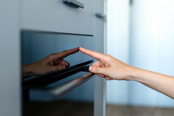 A person selecting a cooking mode on an oven 