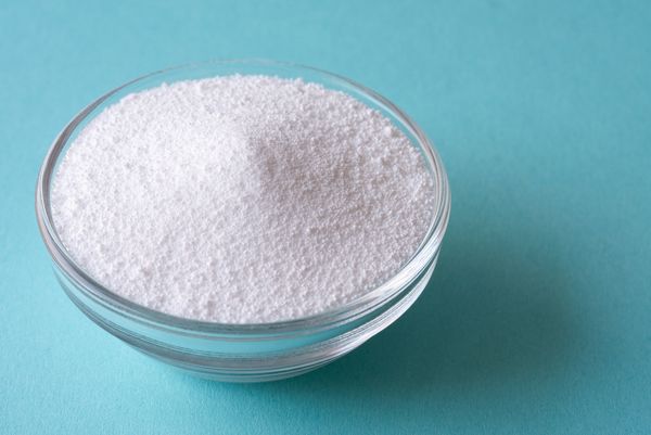 A small ramekin of powder against a blue background 