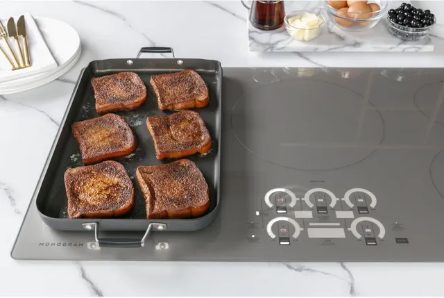 Lamb chops cooking on griddle over the Monogram ZHU36RSTSS induction cooktop