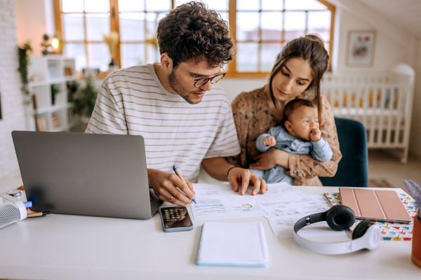 A man, woman, and child sitting a table doing budgeting 