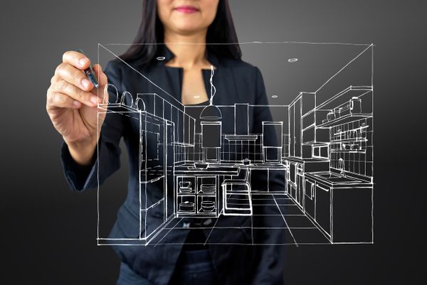 A woman tracing a graphic blueprint of a kitchen remodel 