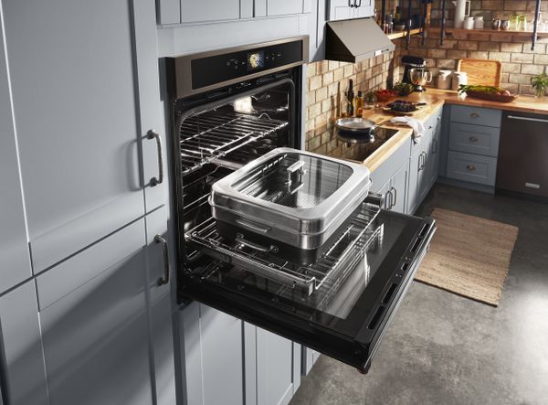 The KitchenAid KOSE900HBS oven featured with its door open and with a Smart Oven+ attachment 