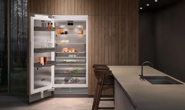 A Gaggenau built-in panel ready refrigerator with shown with its door open in a high-end kitchen 
