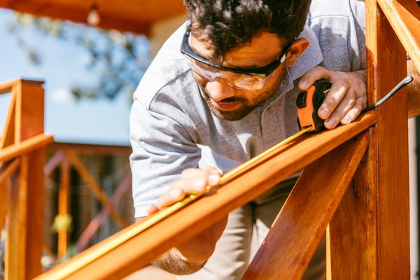 A man measuring a banister 