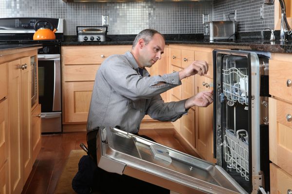 A man installing a dishwasher 
