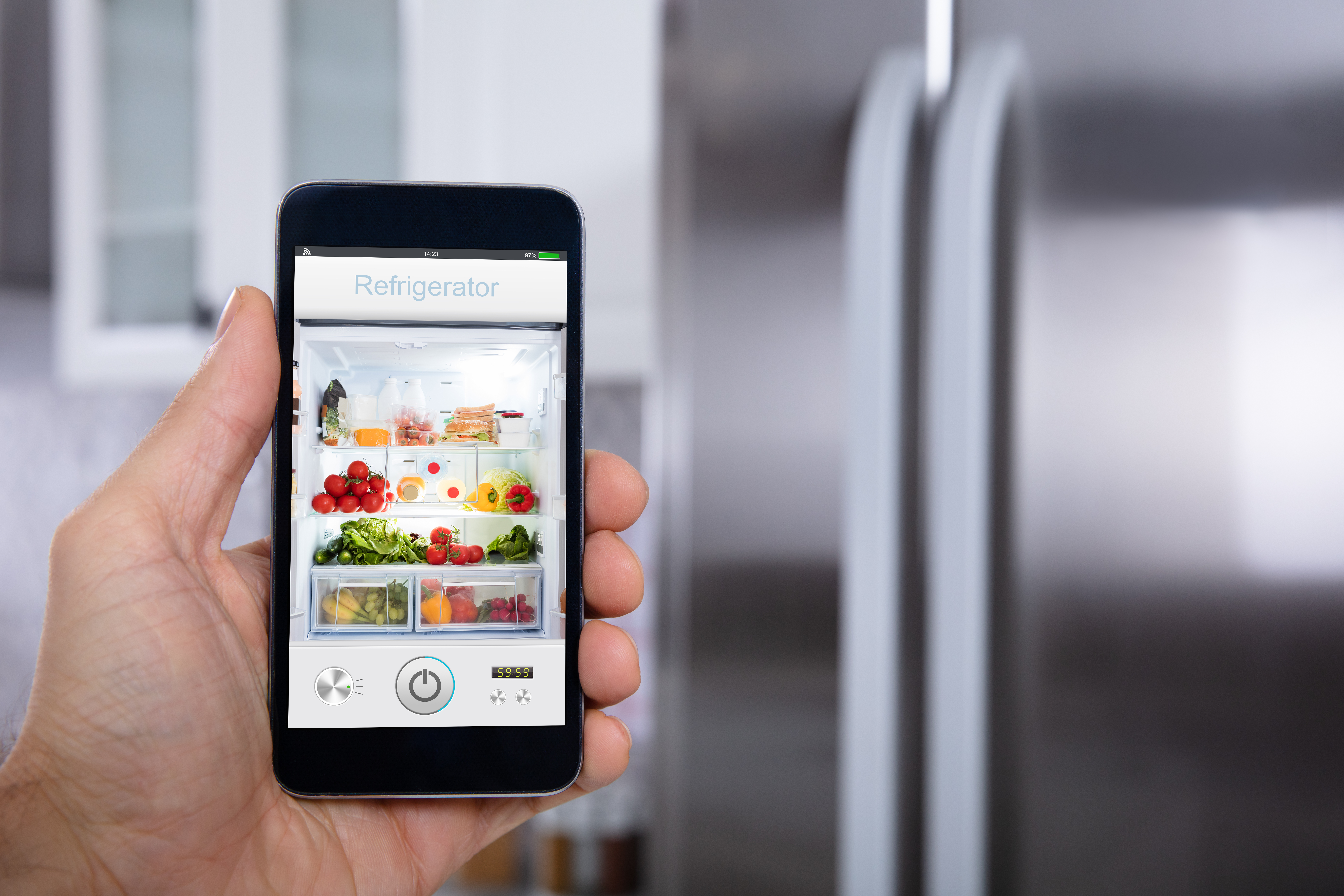 A person holding a smart device showing contents inside of a smart refrigerator 