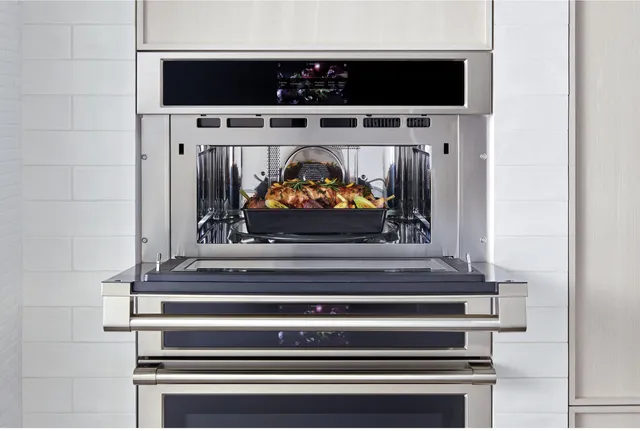 The Monogram ZSB9232NSS 30” speed oven with its door open and a turkey inside 