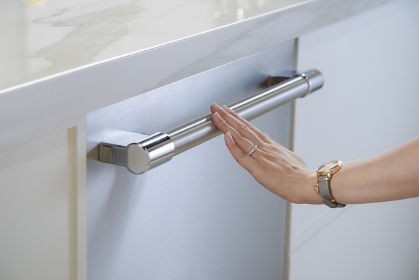A woman touching the handle on a Thermador dishwasher 