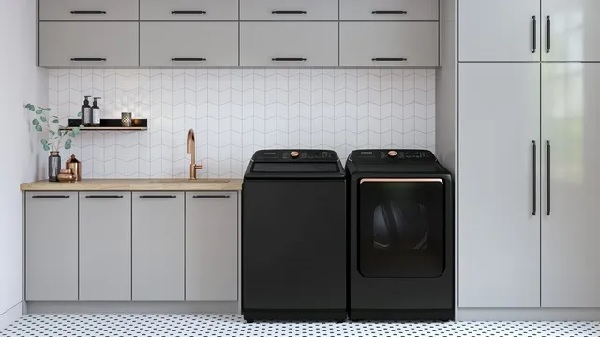 The Samsung WA55A7700AV top load washer with a matching dryer in a laundry room 