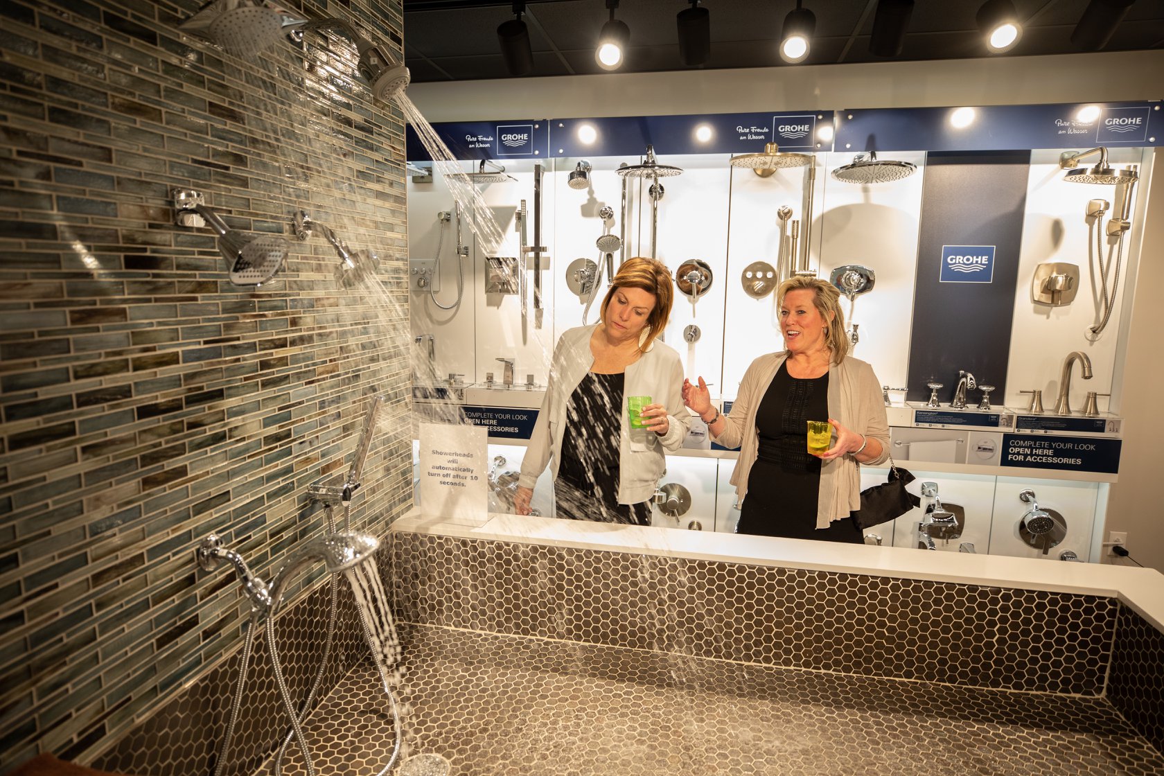 Two women reviewing shower faucets at Don’s Appliances’ WATERSOURCE showroom 