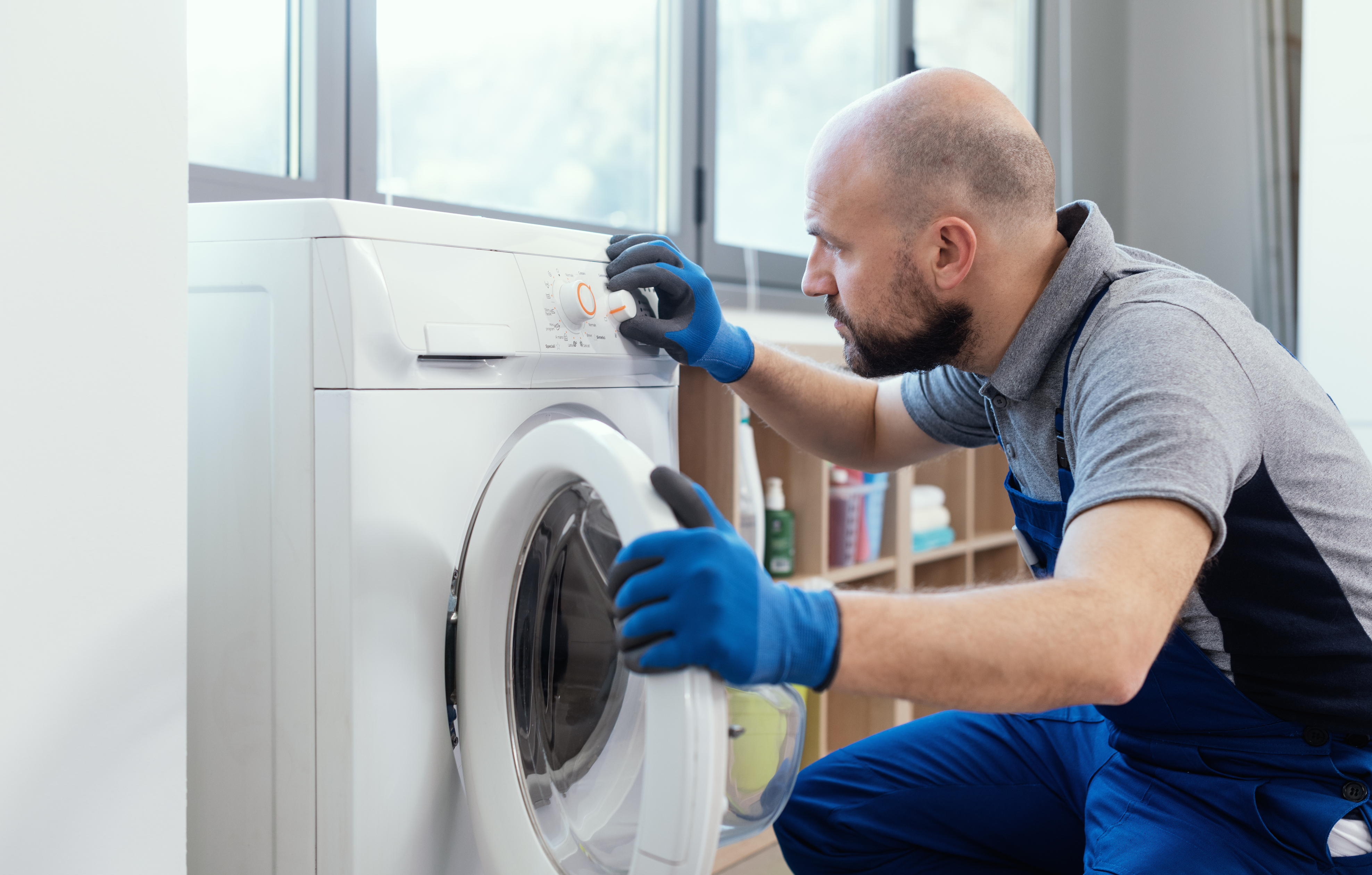 A repairman checking a front load washer 