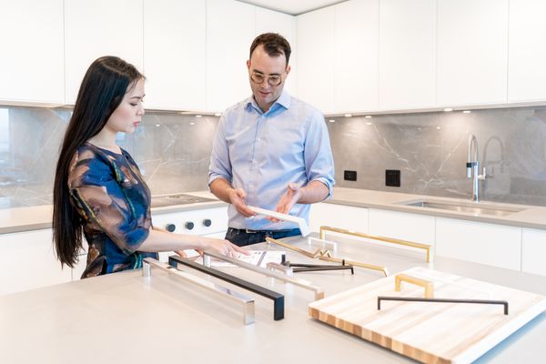 A designer showing a client several appliance hardware options 