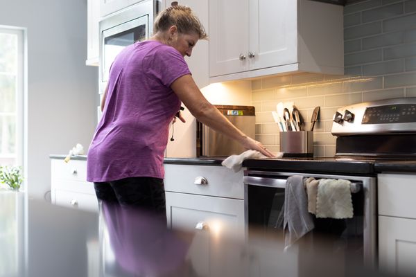 A woman works to clean the top of her electric stove