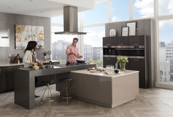 A wide shot of a man and a woman cooking in a kitchen featuring Wolf appliances 