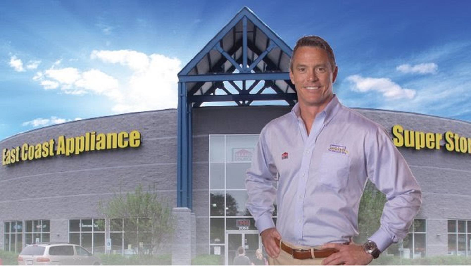 The owner of East Coast Appliance in front of a graphic of an East Coast Appliance location 