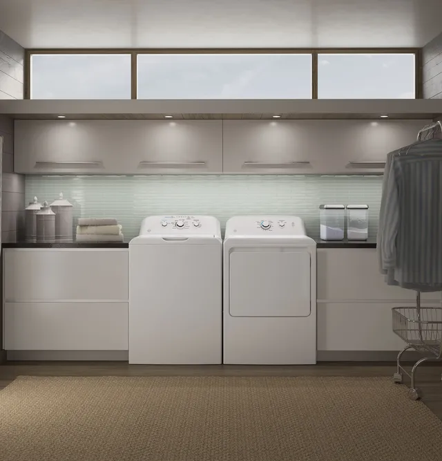 A pair of white Whirlpool top load washer and dryer machines 