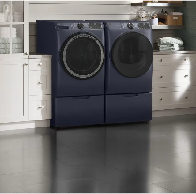 The GE GFD55ESPRRS dryer and matching washer in a laundry room 