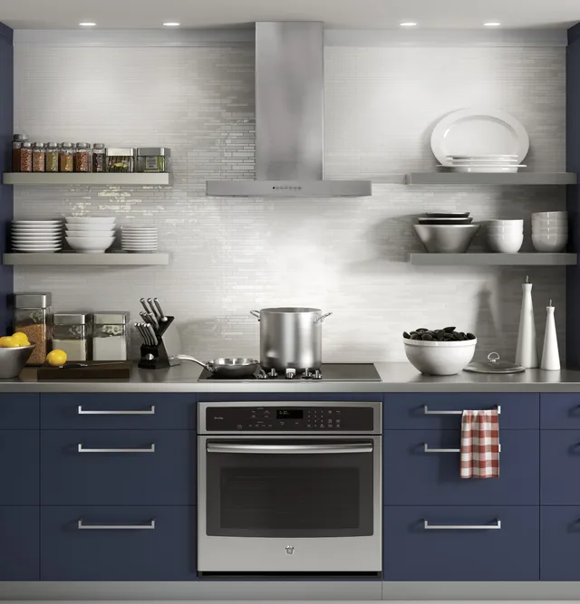 The GE Profile UVW8361SLSS wall mounted range hood over an electric slide in range 