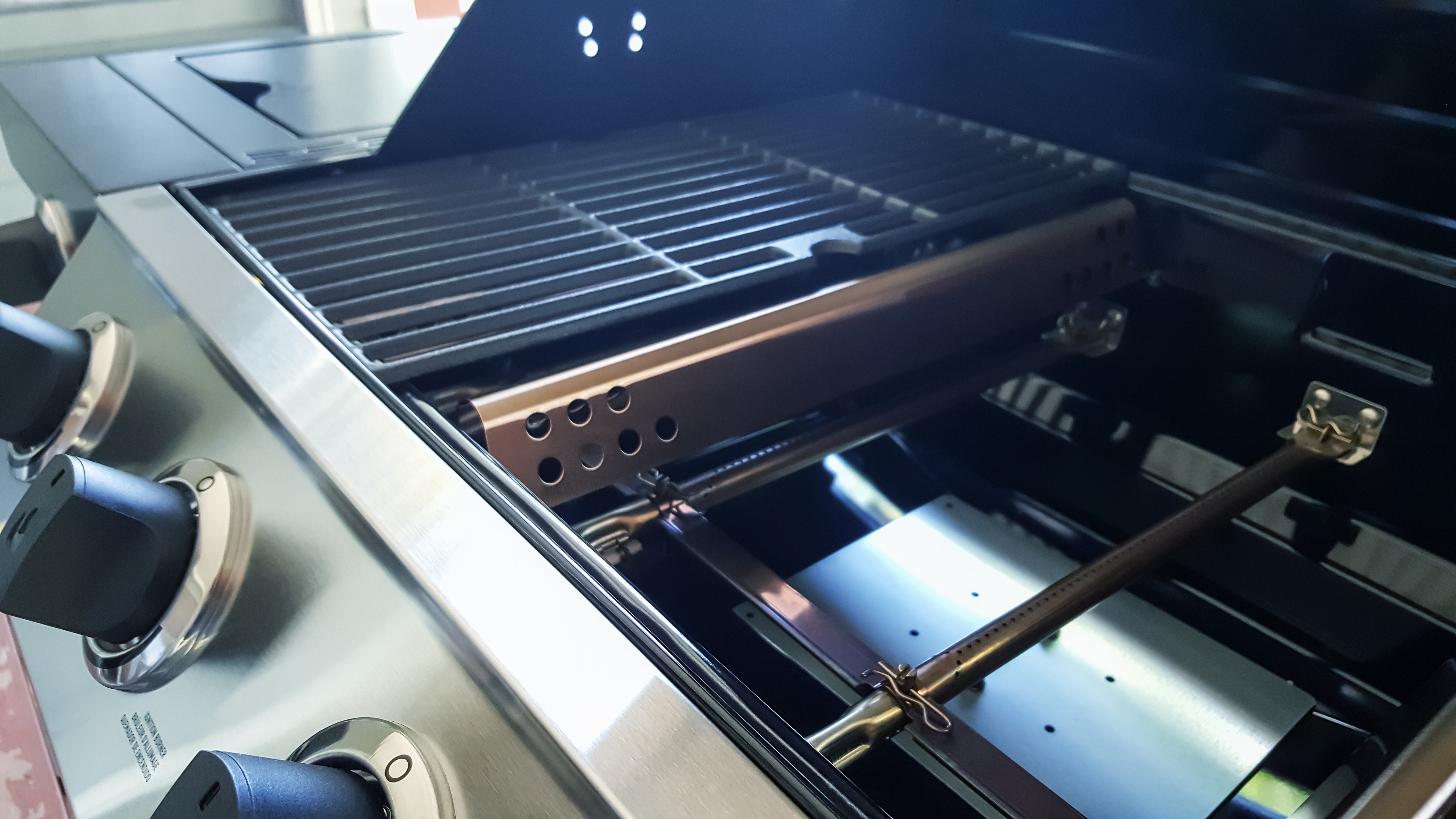 An up close look at the parts on the inside of a gas grill 