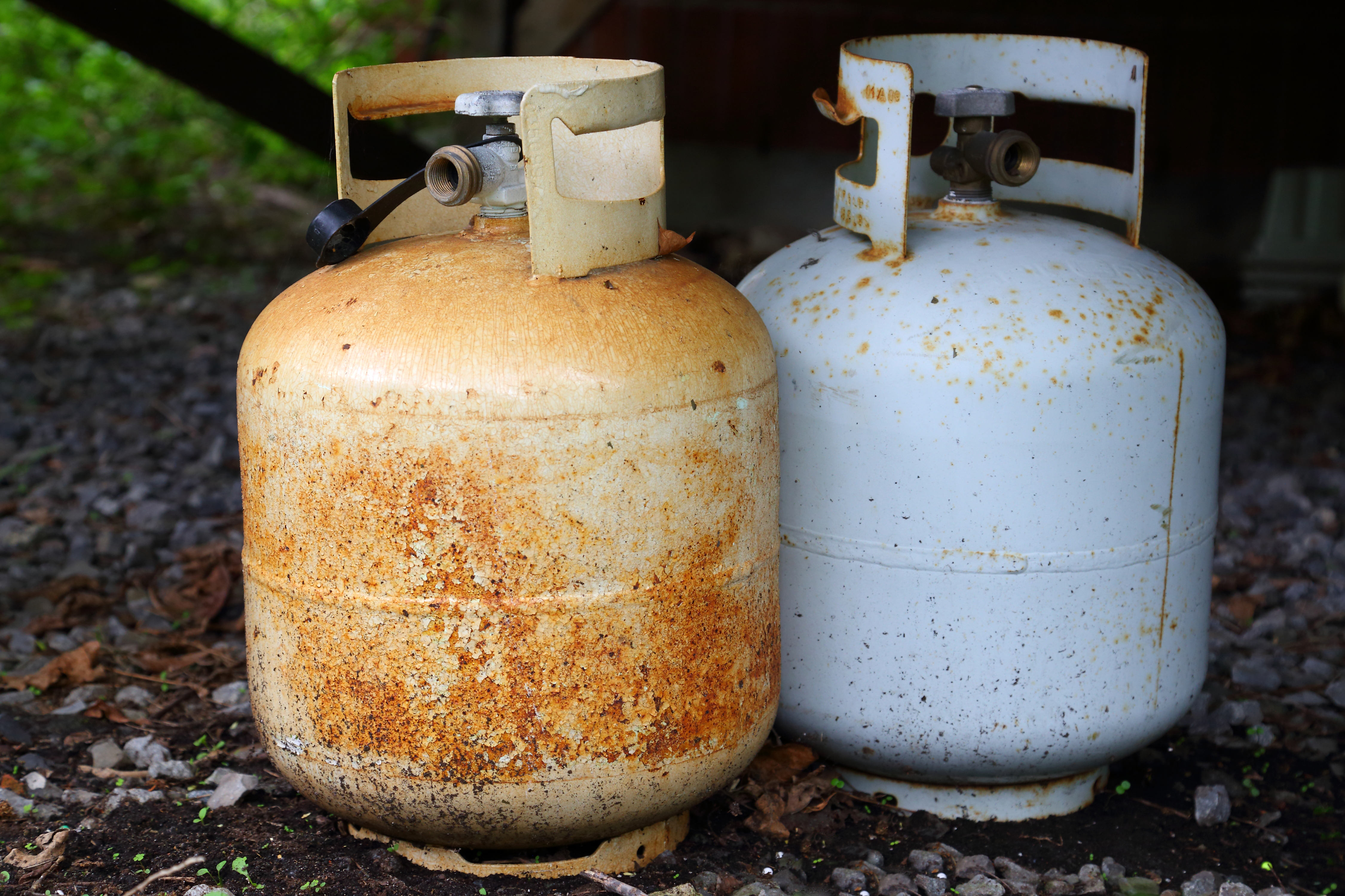 Two rusted propane tanks outside 