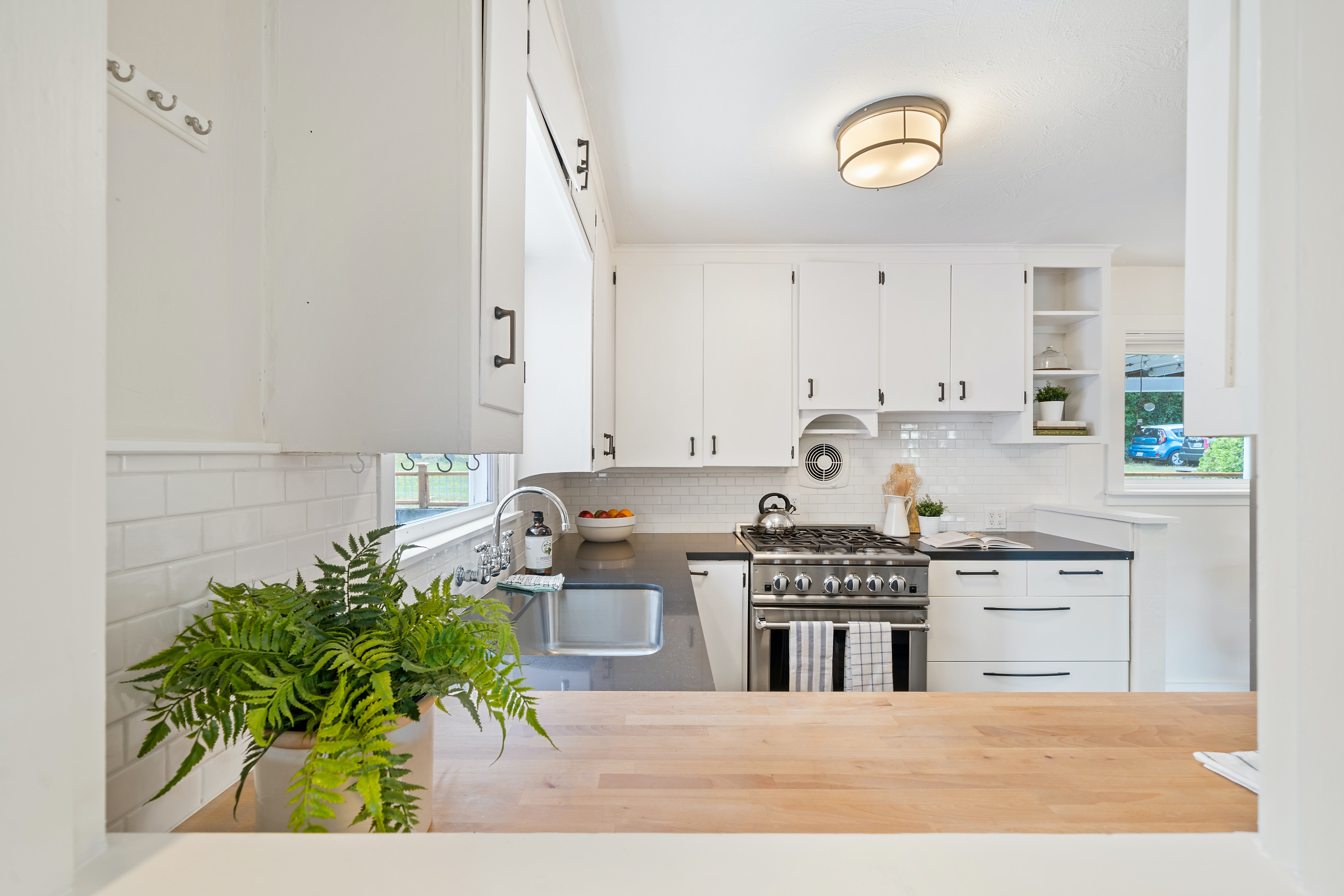 A white kitchen featuring a stainless steel gas range 