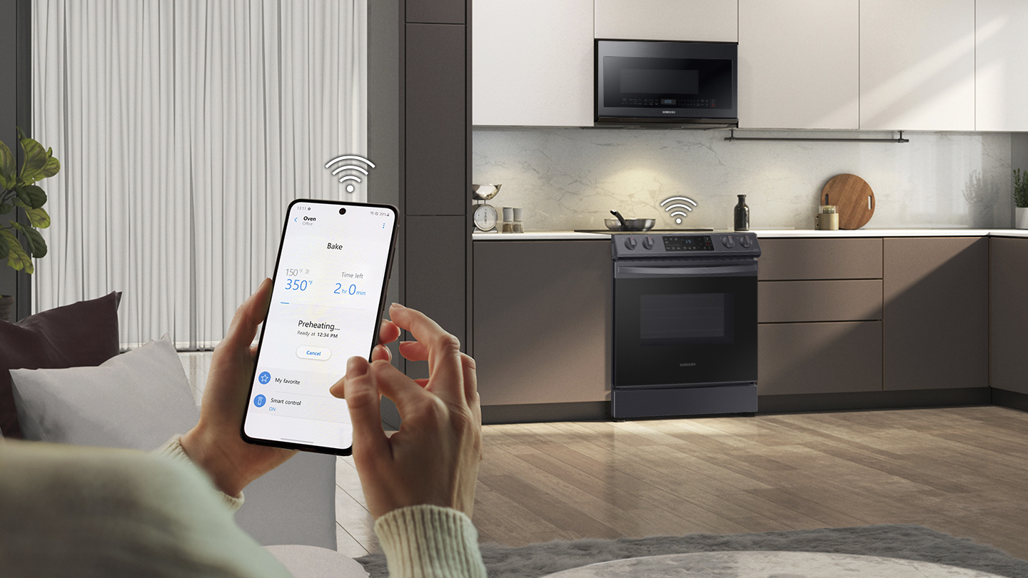 A woman using the SmartThings app to connect to a Samsung range 