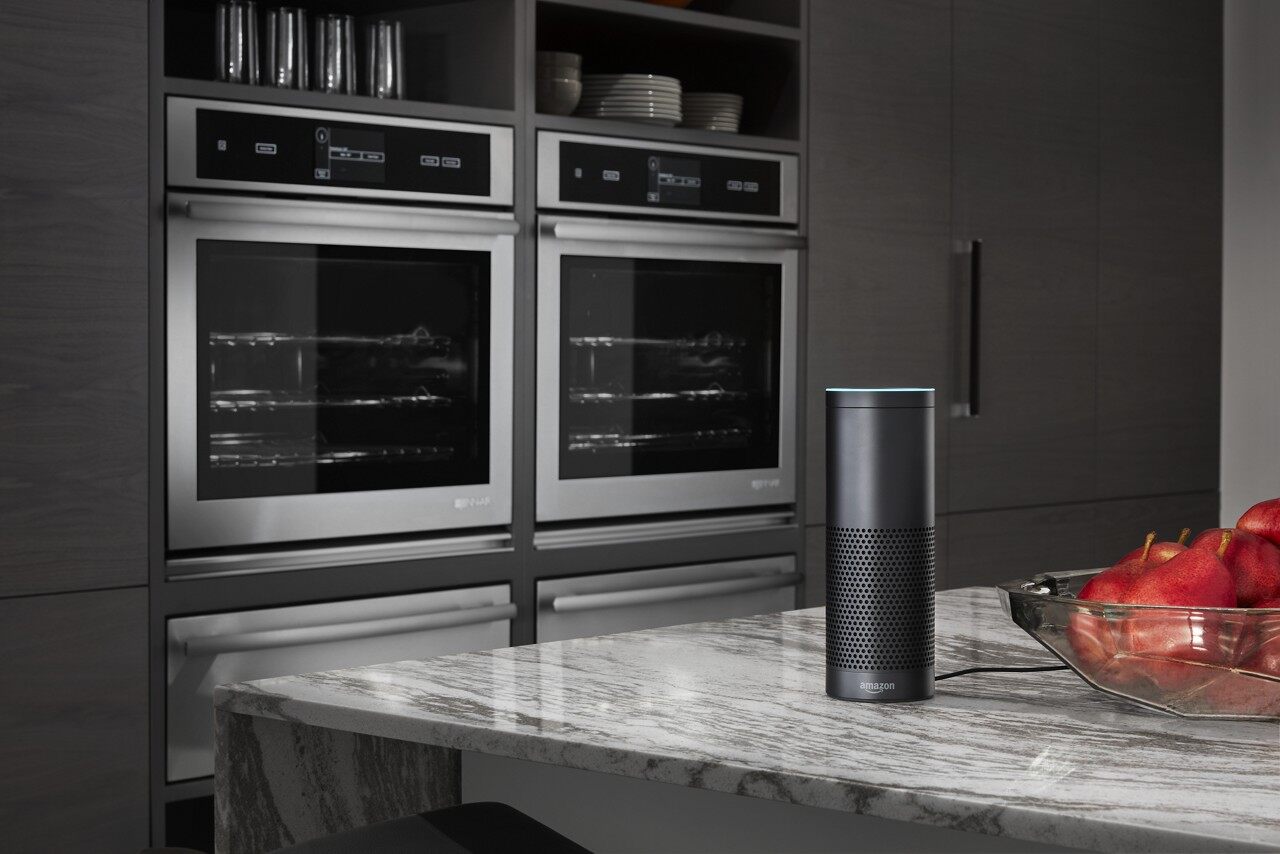 A wide shot of two KitchenAid smart ovens and an Alexa smart device 