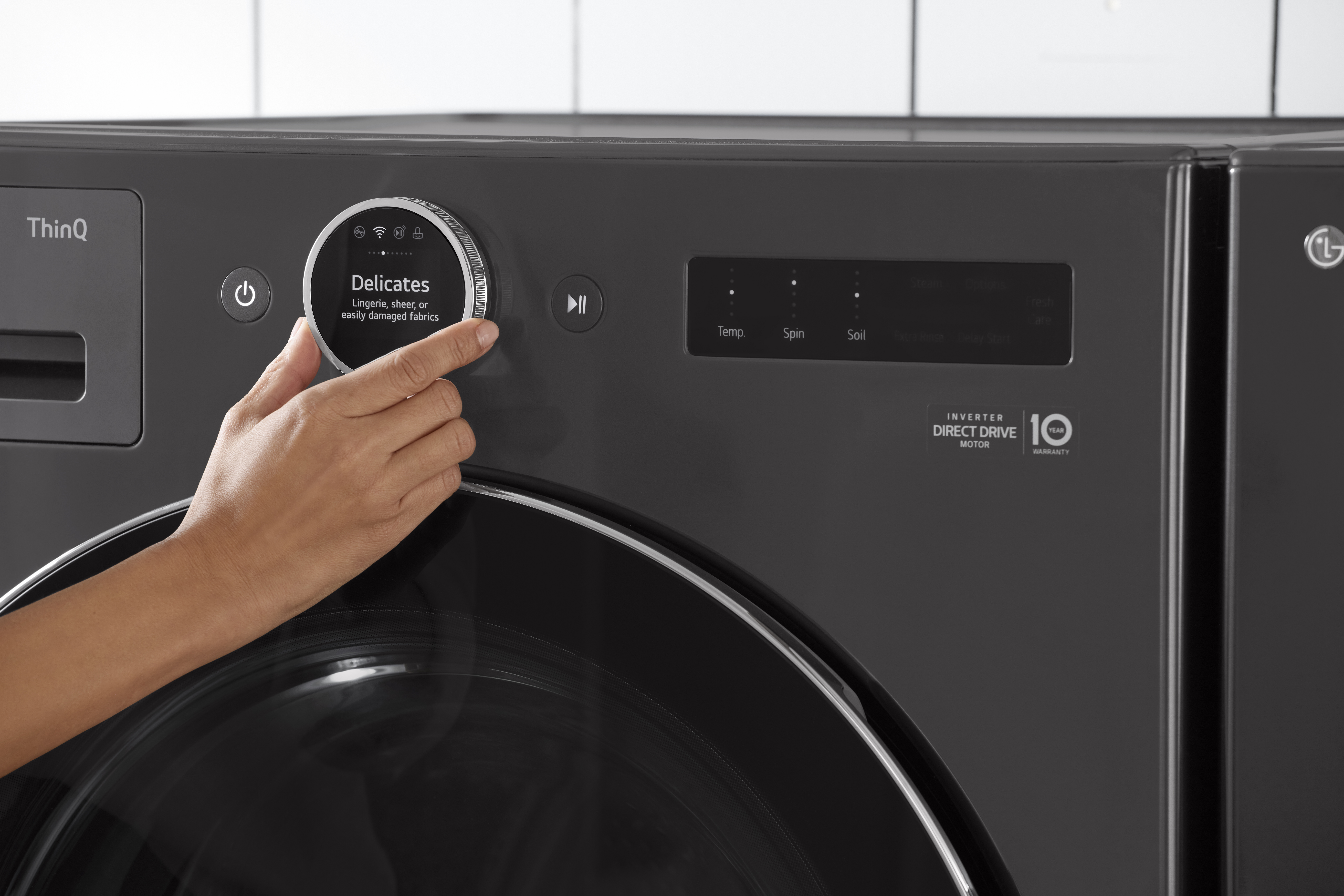 A user selecting the Delicate soil level on an LG front load washing machine