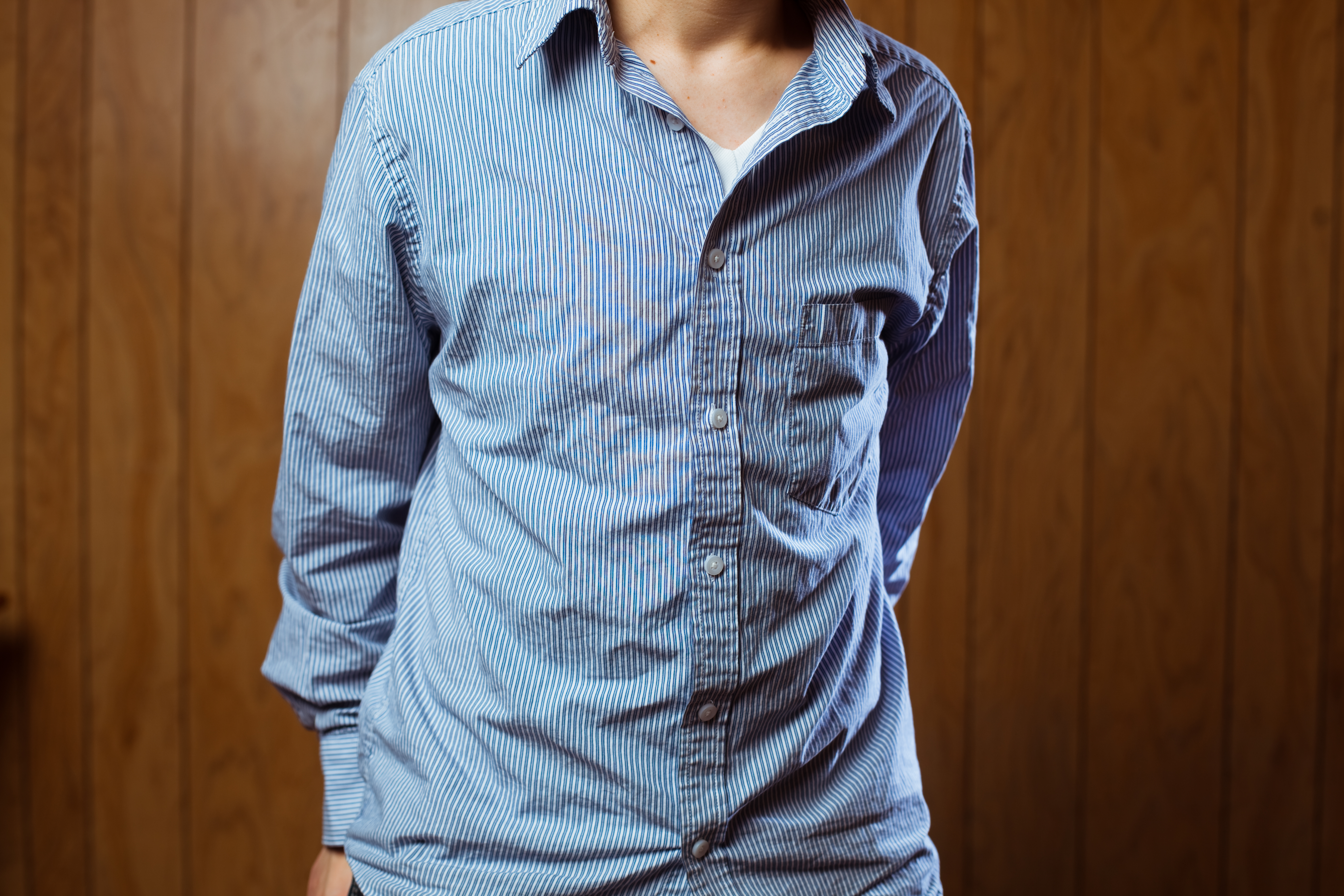 Shot of person in wrinkled blue pinstripe button up shirt