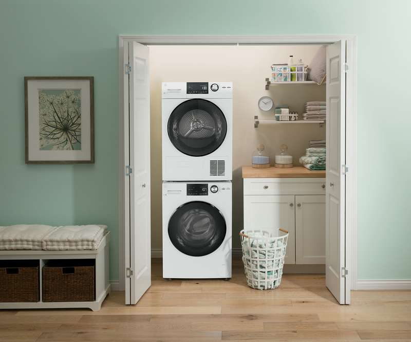 Modern laundry room with GE laundry appliances stacked on top of each other.