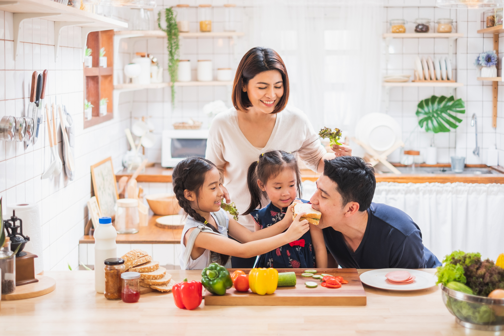 family making sandwiches and feeding their parents