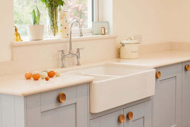 Front view of a dual sided farmhouse kitchen sink with eggs on the counter beside it