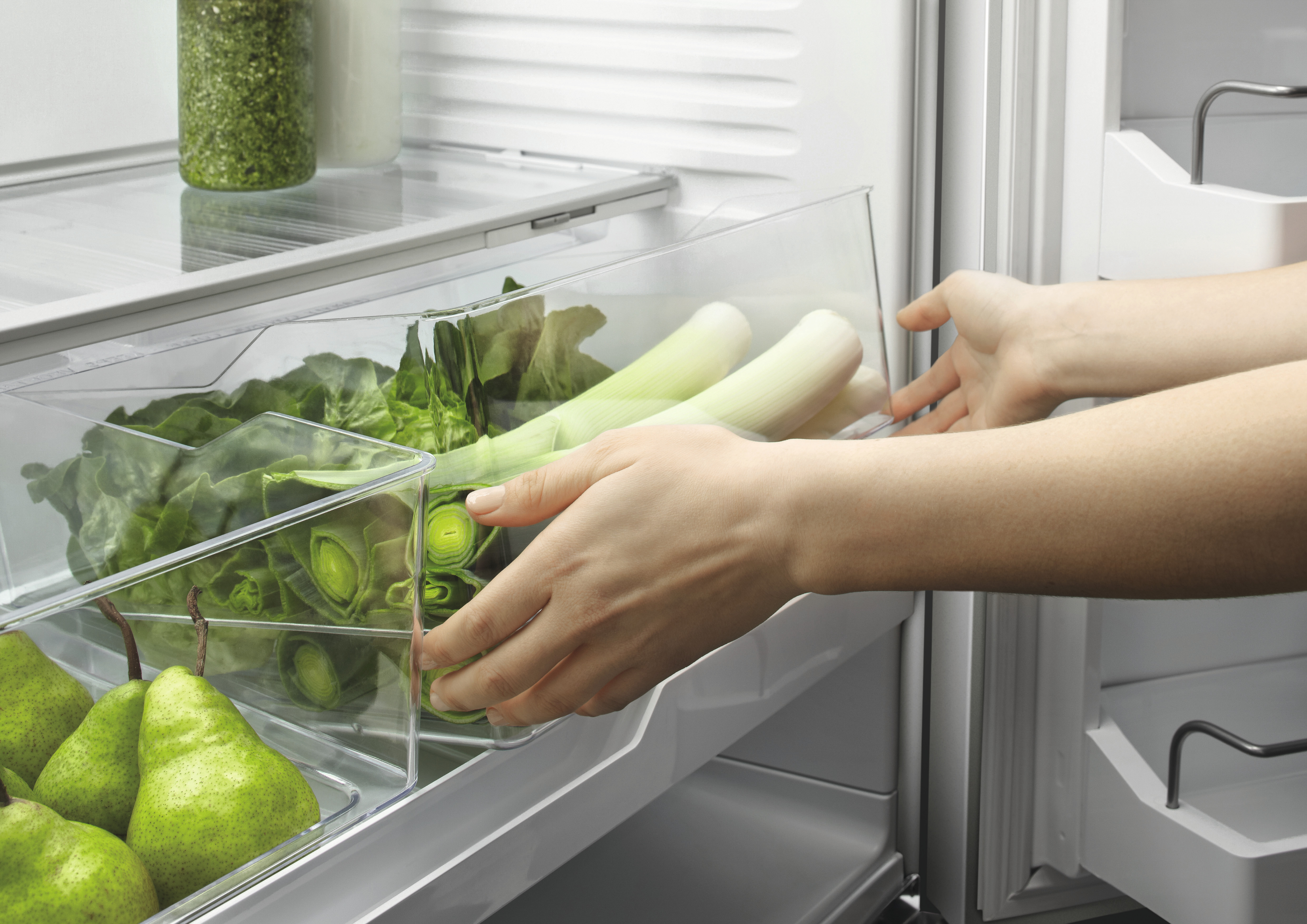 person using flexible storage feature on RF201ADJSX5 french door refrigerator to store leeks and pears