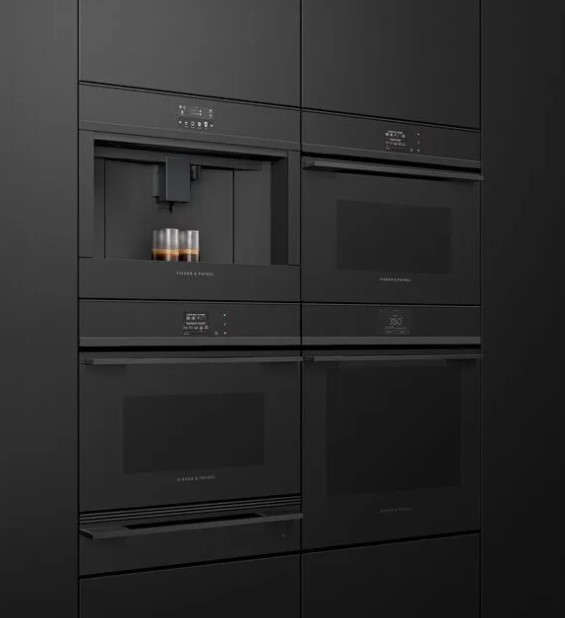 Fisher & Paykel wall ovens and coffee maker are installed in a black wall.