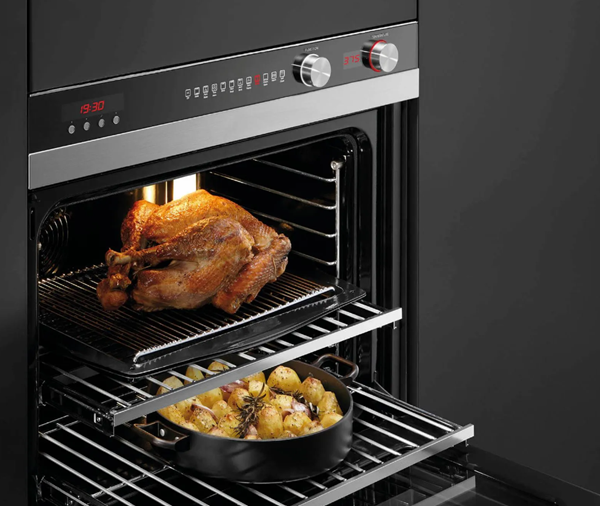 Fisher and Paykel oven is shown with door open and food cooking inside