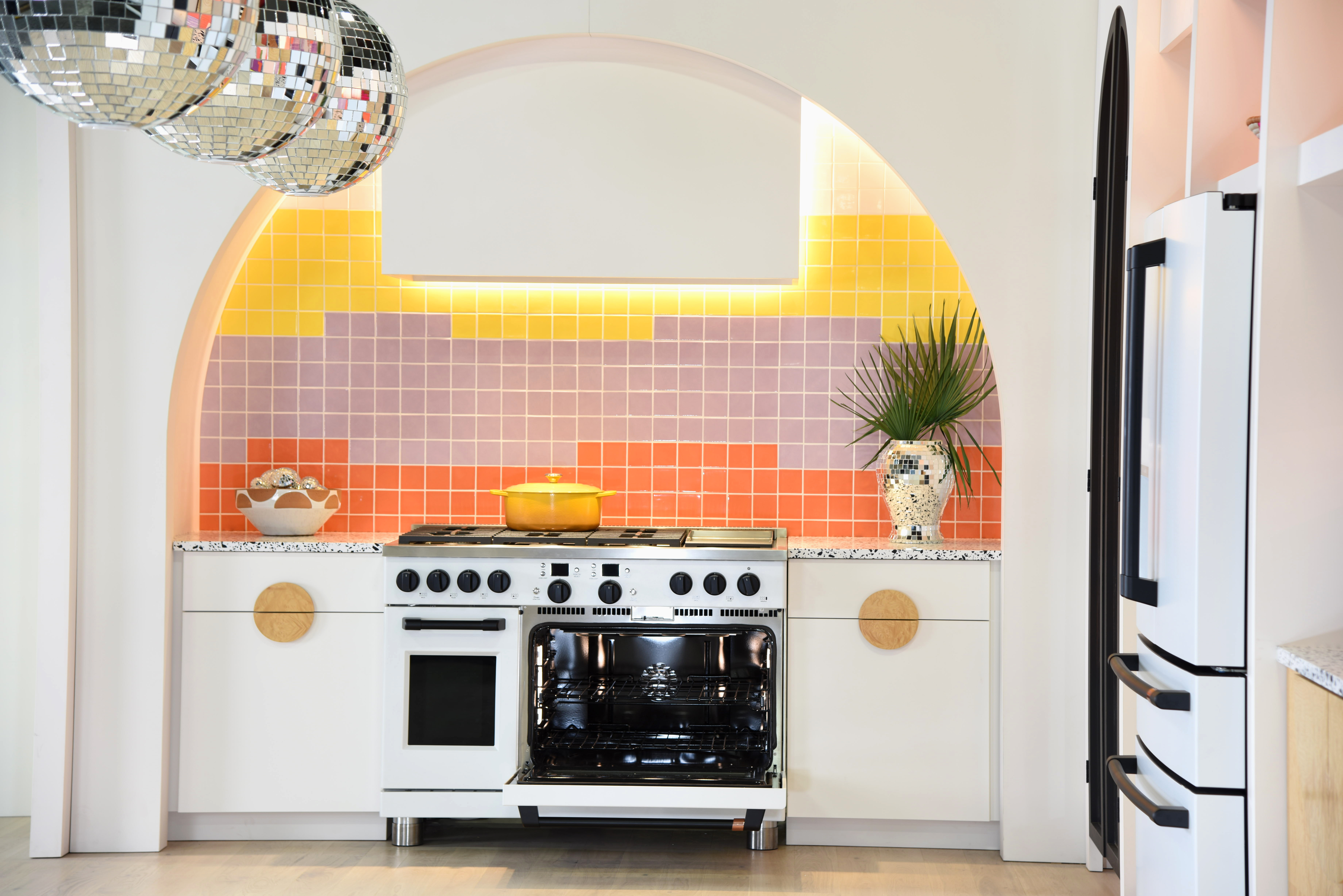 A multi-colored kitchen feature Café matte white appliances 