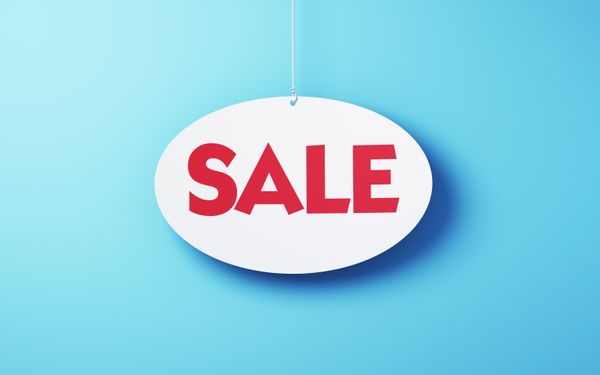 A white sign with red letters spelling sale on a blue background 