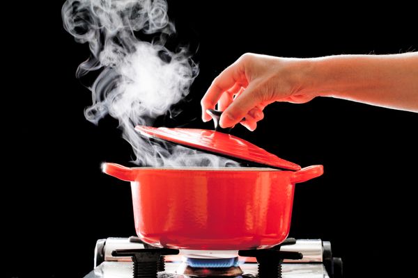 Steam releasing from a red Dutch oven 
