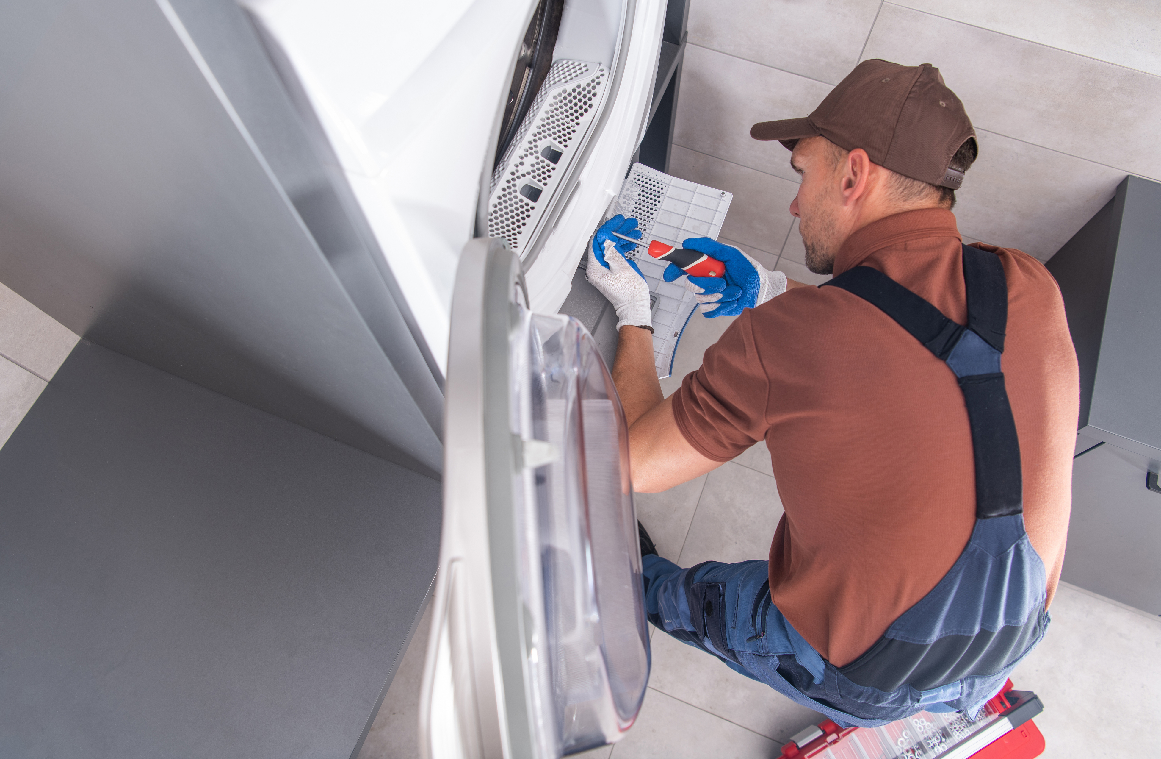 A repairman fixing a dryer 