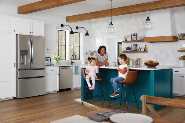 A family enjoying a meal inside a kitchen featuring Frigidaire Gallery appliances 