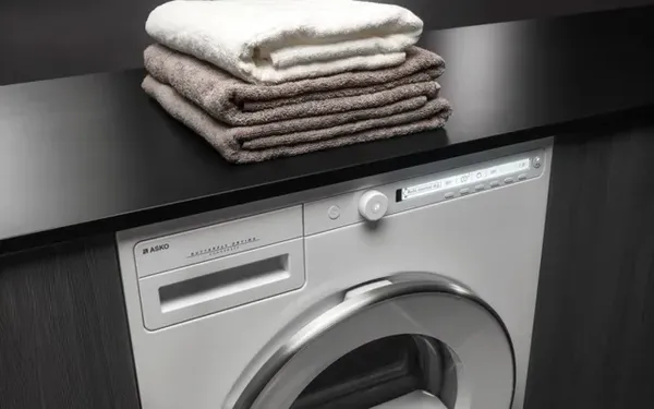 The ASKO Classic T208HW ventless dryer featured with a stack of towels 