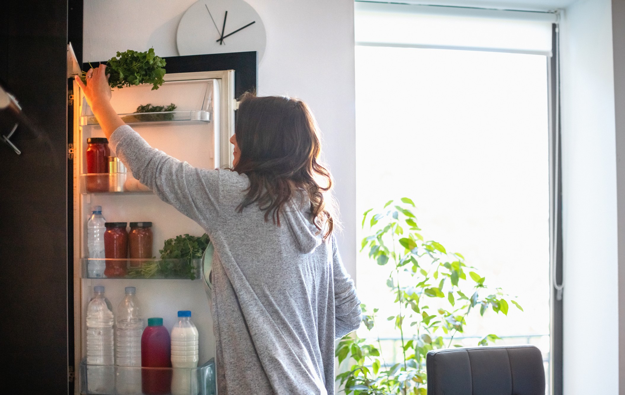 woman reaching into her refrigerator
