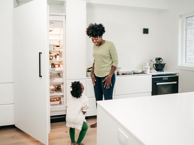 Mother and son talking in front of the kitchen fridge