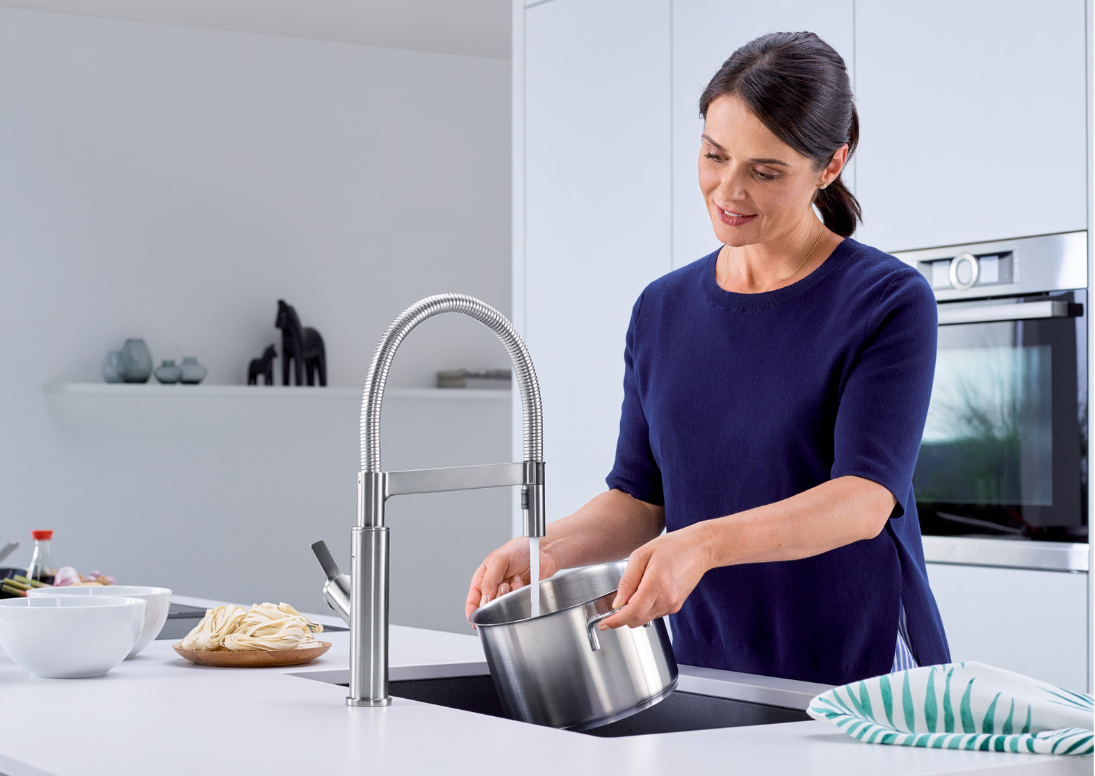 Woman using the Blanco 401993 touchless kitchen faucet to fill a pot with water