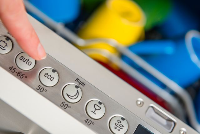Close view of a person pressing the Eco mode button on their dishwasher.
