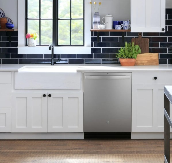 Stainless steel GE dishwasher built into white kitchen cabinets