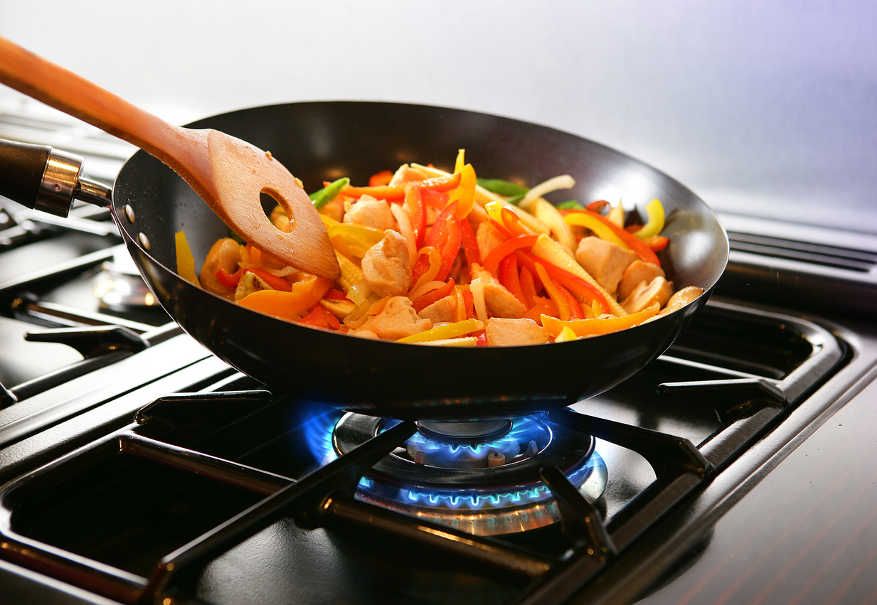 sweet bell peppers sauteeing in a pan over gas flame